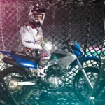 Danger Globe rider on Honda motorcycle inside steel cage - professional stunt performer ready for Globe of Death show